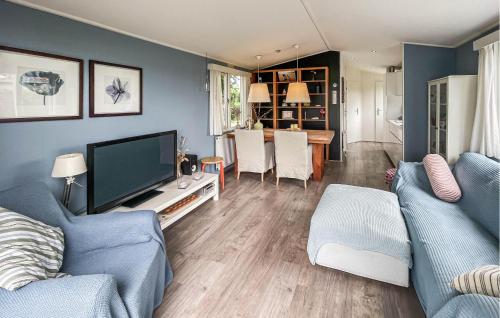 a living room with a couch and a tv at 2 Bedroom Nice Home In Lauwersoog in Lauwersoog