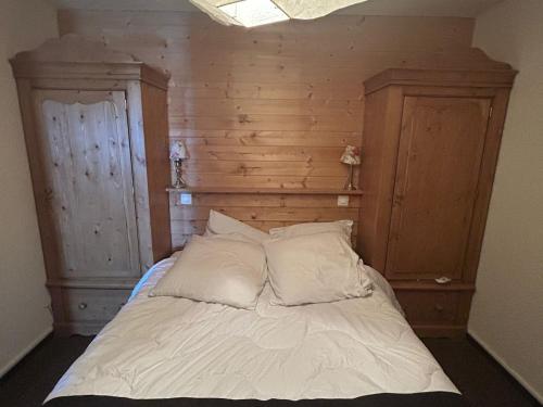 un lit avec des draps blancs et des oreillers dans une chambre dans l'établissement Appartement confort pour 4/6 pers. au cœur de la station avec terrasse - FR-1-814-140, à Besse-et-Saint-Anastaise