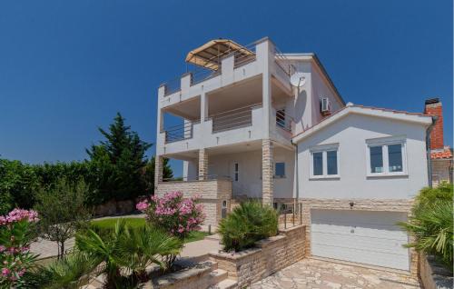 a large white house with a lot of plants at Apartment Maslenica in Jasenice