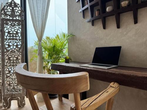 a laptop computer sitting on a desk with a chair at V222 Zen Sea View Villa Pool, Hot Tub & Chess in Plai Laem