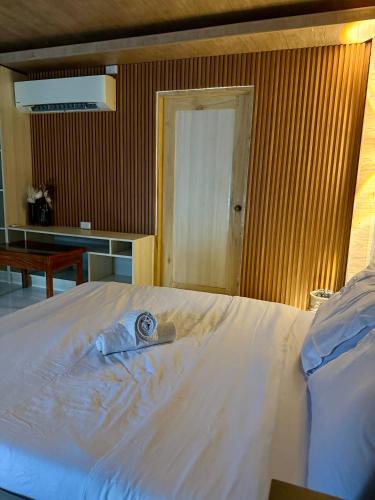 a bedroom with a bed with a towel on it at Jardin De Ysabelle in Tagpupungan