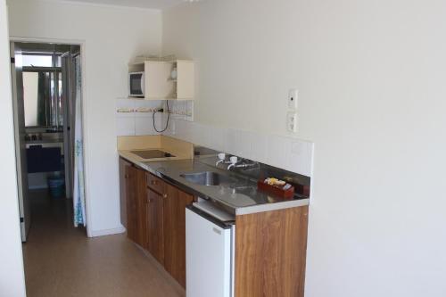 a kitchen with a sink and a counter top at Malones Spa Motel in Rotorua