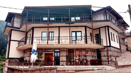 a large house with a balcony on top of it at Family hotel Valchanovata Kashta in Fotinovo