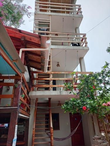 a building with stairs and a dog sitting on a balcony at Hostal Moai in Montañita