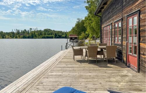 a wooden dock with a table and chairs on the water at Lovely Home In Gränna With Lake View in Gränna
