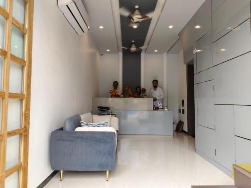 a lobby with a blue couch and people standing at a counter at Jawai Rock Hotel in Sheoganj