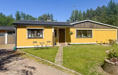 a yellow house with chairs in a yard at 3 Bedroom Cozy Home In Nässjö in Nässjö