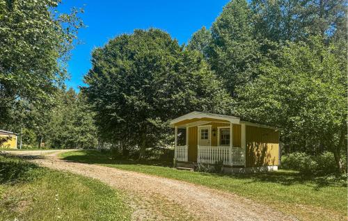 a small yellow house on a dirt road at 3 Bedroom Cozy Home In Nässjö in Nässjö