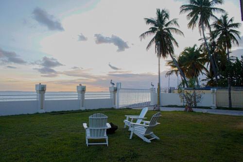 two chairs and a table on a lawn near the ocean at Villa Las Tres Gaviotas I in Salinas