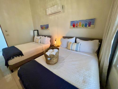 two beds in a small room with a basket on them at Villa Las Tres Gaviotas I in Salinas