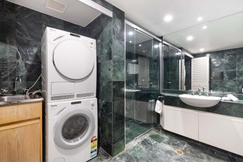 Un baño con lavadora y lavabo. en Mirage Resort Villa 147 with access to Sheraton Facilities, en Port Douglas