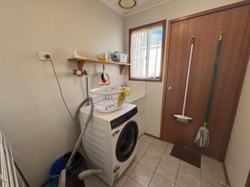 a laundry room with a washing machine in the corner at Alwyns By The Sea in Inverloch