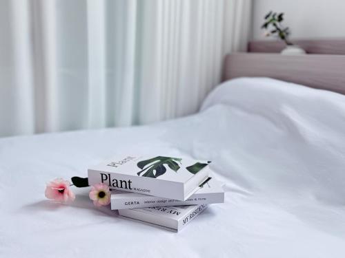a stack of books sitting on top of a bed at HausKomma 서울 홍대,이태원,명동 짐보관 무료 주차 엘레베이터 새아파트 in Seoul