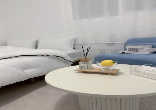 a white bedroom with a bed and a table at 정담 신도림역 투룸 무료주차 in Seoul
