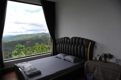 un lit dans une chambre avec une grande fenêtre dans l'établissement Homestay Villa White House, 