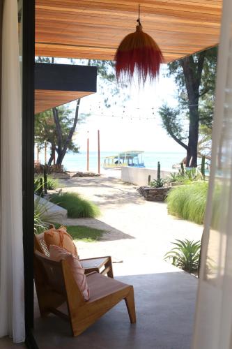 a chair on a porch with a view of the beach at The Beach House in Gili Meno