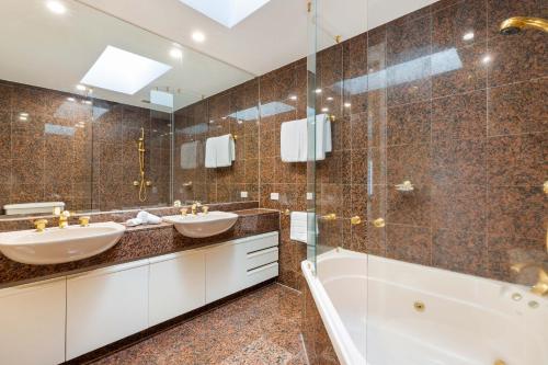 Un baño con dos lavabos y una ducha. en Mirage Resort Villa 152 with access to Sheraton Facilities, en Port Douglas