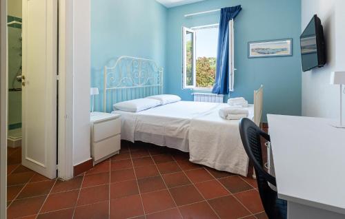 a blue bedroom with a bed and a window at 5 Bedroom Awesome Home In Casalvelino in Casal Velino