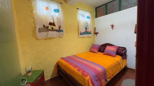 1 dormitorio con 1 cama en una pared amarilla en Refugio tornasol, en Duitama