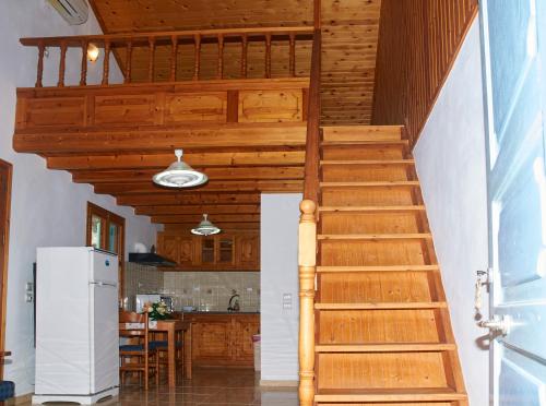 a wooden staircase in a kitchen with a refrigerator at Athina Studios in Symi