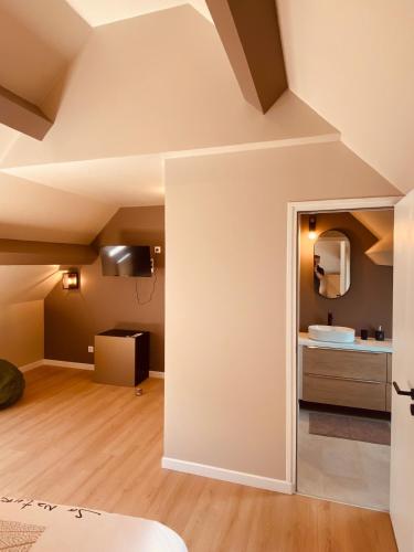 an attic room with a sink and a mirror at Villa La perle des Sylves in Neufchâtel-Hardelot