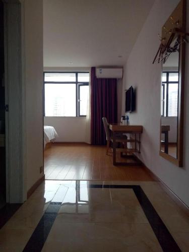 a living room with a table and a room with a window at GreenTree Inn Shangrao Qianshan hekou old town Xinjiang longting shell hotel in Shangrao
