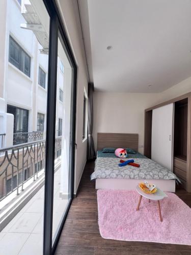 a bedroom with two beds and a balcony at Homestay Cọ Xanh 8 GenZ in Hòa Bình