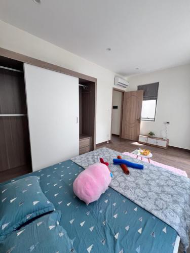 a bedroom with a large bed with a pink pillow on it at Homestay Cọ Xanh 8 GenZ in Hòa Bình