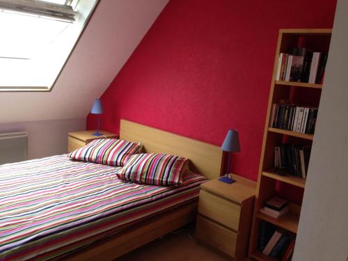 a bedroom with a bed and a book shelf at Duplex proche plage et centre ville in Concarneau