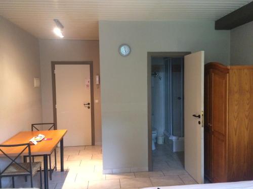 a room with a table and a clock on a wall at Condo Gardens Brussels in Brussels