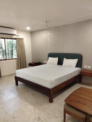 a bedroom with a large bed and a table at Alpine Cloud Resort in Yercaud