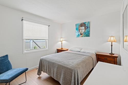 a bedroom with a bed and a chair and a window at Shore Oasis in Seaside Heights