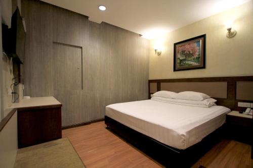 a hotel room with a bed and a bathroom at Ming Paragon Hotel in Kuala Terengganu