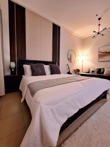a bedroom with a large white bed in a room at Hills Residences by JuJu Staycation in Manila