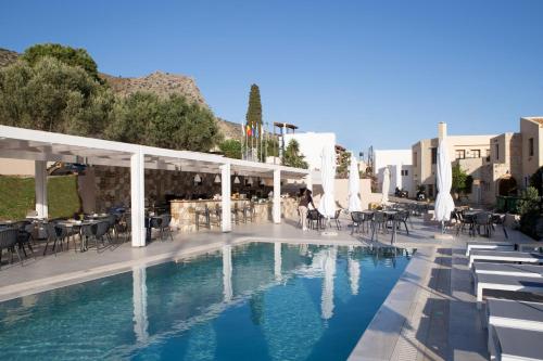a pool at a hotel with tables and chairs at Sundance Apartments & Suites in Hersonissos