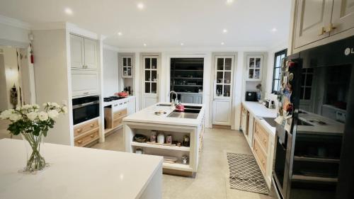 a kitchen with white cabinets and a white counter top at VILLA SCALINA Seaside Hideaway - 7 Bedroom - Pool - Gym - Walk to beach in Calodyne