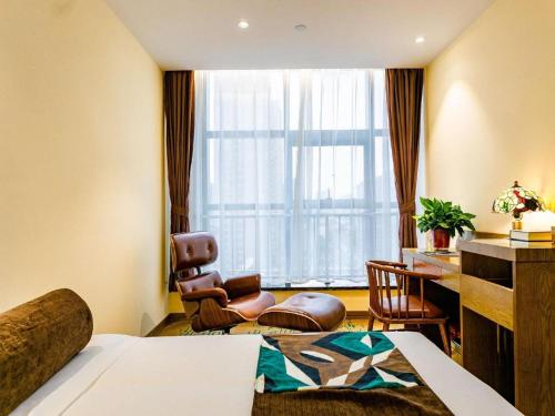a hotel room with a bed and a chair and a desk at James Joyce Coffetel· Xianyang Renmin Road Central Square Store in Xianyang