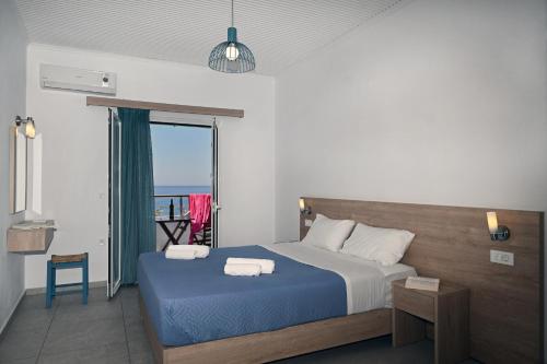 a bedroom with a bed with two towels on it at Calypso in Agia Roumeli