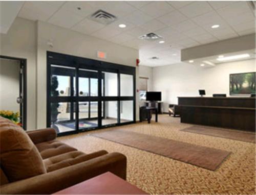 an office with a waiting room with a couch and a desk at Super 8 by Wyndham Innisfail in Innisfail