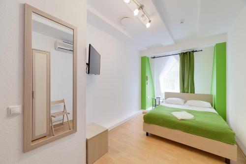 モスクワにあるMinima Kuzminkiのベッドルーム(緑のベッド1台、鏡付)