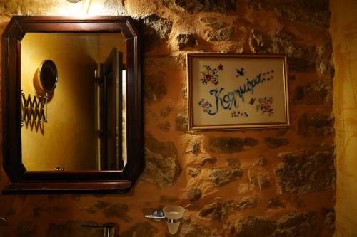 a mirror on the wall of a bathroom at kritikies1 in Pitsidia