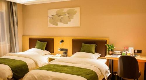 a hotel room with two beds and a desk at GreenTree Inn Express Chuzhou Langya District Government Chuhe Road in Chuzhou