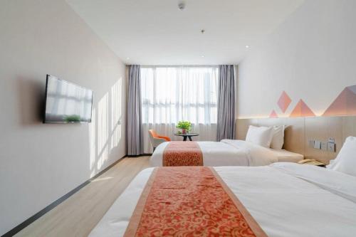a hotel room with two beds and a television at Borrman Hotel Hefei Yaohai Wanda Linquan East Road in Hefei