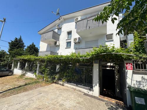a white building with a gate in front of it at Apartments TRI SRCA in Sutomore