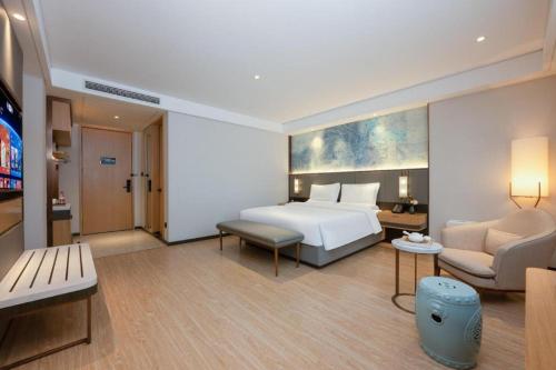 a hotel room with a bed and a living room at Green Tree Inn Xuzhou Tongshan Wanda Plaza Yuquanhe Metro Station in Xuzhou
