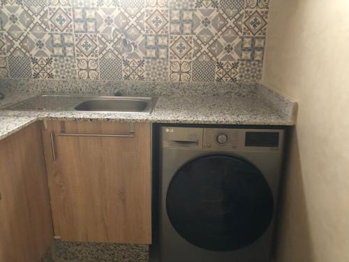 een keuken met een spoelbak en een wasmachine bij Darkoum Apartment Anza in Agadir