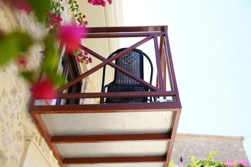 a balcony with a black chair on a building at kritikies1 in Pitsidia
