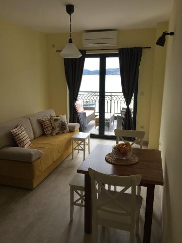 un soggiorno con divano e tavolo con sedie di Apartments Seaside Baosici a Herceg-Novi