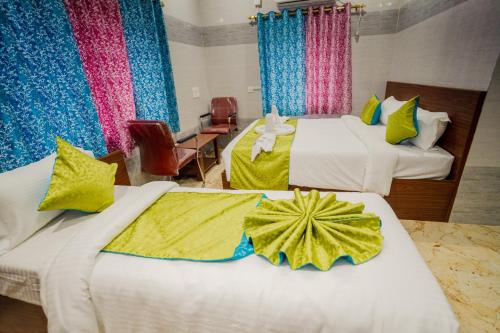 a hotel room with two beds with yellow and blue curtains at Hotel Mirka Plaza in Bhubaneshwar