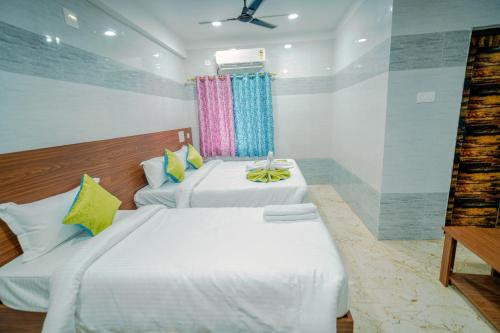a bedroom with two beds and a window at Hotel Mirka Plaza in Bhubaneshwar